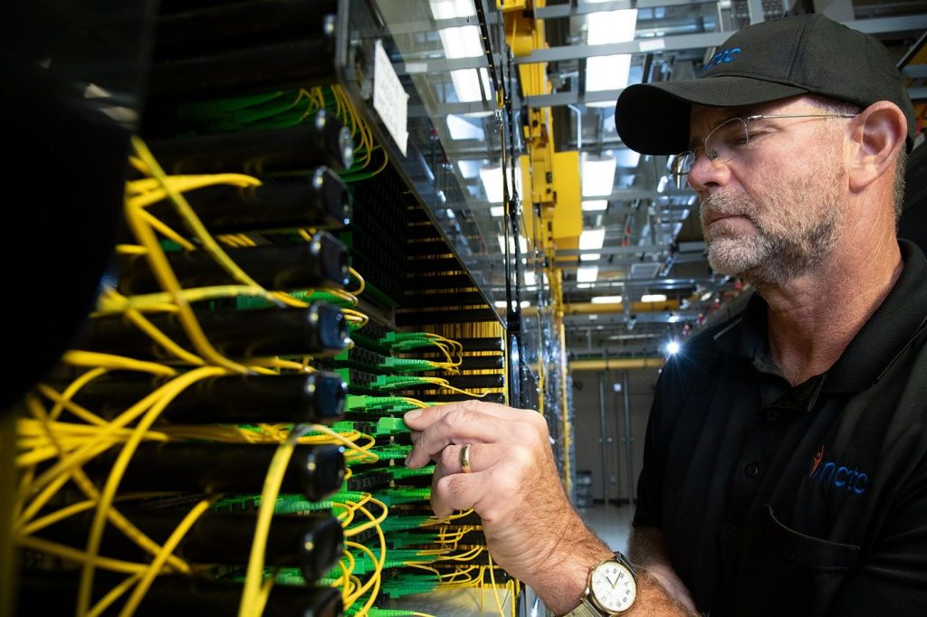technician installing fiber optic cables for broadband network